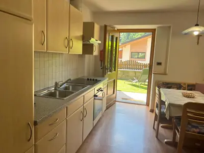 a kitchen with a sink and a table and a dining room at Apartments Bernard in Aldino