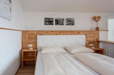 a bedroom with two beds and two night stands at Garni Zatzerhof in Castelrotto