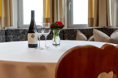 a bottle of wine and two glasses on a table at Garni Zatzerhof in Castelrotto