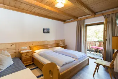 a bedroom with a large bed and a window at Garni Zatzerhof in Castelrotto