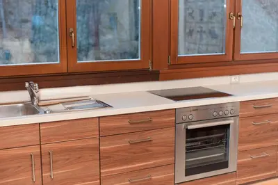 a kitchen with wooden cabinets and a stainless steel oven at Hotel Lambrechtshof in Appiano sulla Strada del Vino