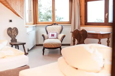 a room with two chairs and a desk and windows at Hotel Lambrechtshof in Appiano sulla Strada del Vino