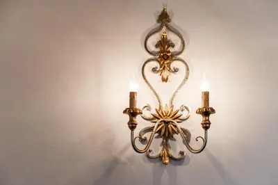 a chandelier with three candles hanging on a wall at Hotel Lambrechtshof in Appiano sulla Strada del Vino
