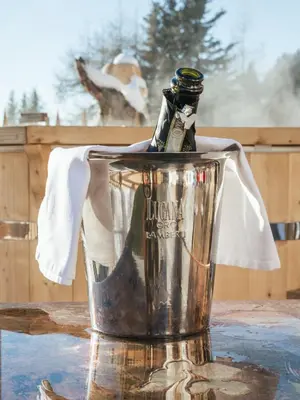 a bottle of champagne in a bucket on a table at Rifugio Graziani Hütte in San Vigilio Di Marebbe