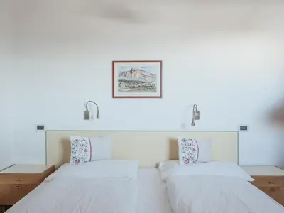 two beds in a room with white walls at Rifugio Graziani Hütte in San Vigilio Di Marebbe