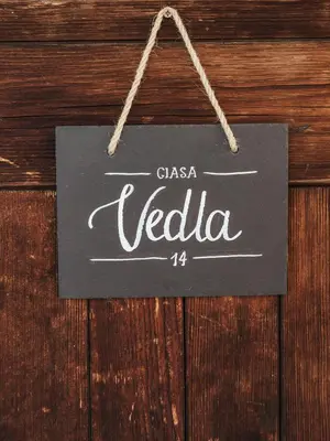 a sign that says chica vella hanging on a wooden wall at Rifugio Graziani Hütte in San Vigilio Di Marebbe