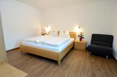 a bedroom with a bed and a chair at Apartment Plan de Socrep in Santa Cristina in Val Gardena