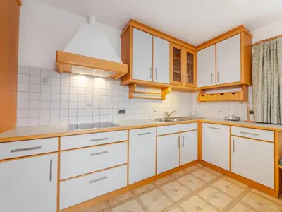 a kitchen with white cabinets and wooden counters at Apartment Plan de Socrep in Santa Cristina in Val Gardena