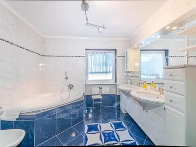 a blue and white bathroom with a tub and a sink at Apartment Plan de Socrep in Santa Cristina in Val Gardena