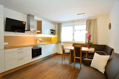 a kitchen and dining room with a table and a couch at Apartment Plan de Socrep in Santa Cristina in Val Gardena