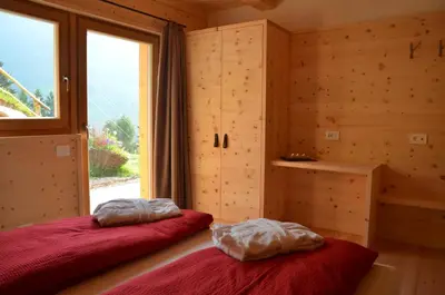 two beds in a room with a window at Naturchalet in San Vigilio Di Marebbe