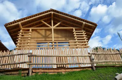 a wooden building with a fence in front of it at Naturchalet in San Vigilio Di Marebbe