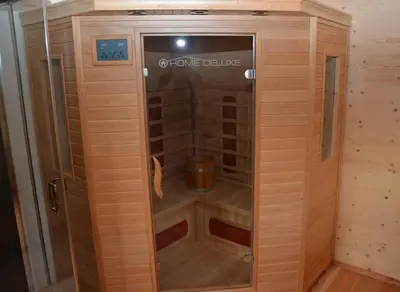 a sauna with a shower in a wooden cabin at Naturchalet in San Vigilio Di Marebbe
