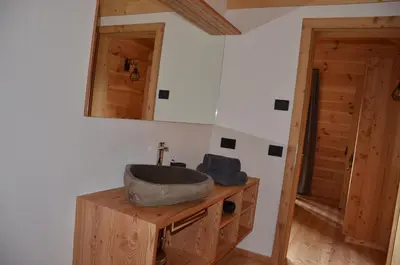 a bathroom with a sink on top of a wooden cabinet at Naturchalet in San Vigilio Di Marebbe
