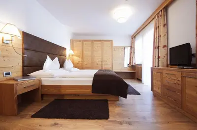 a bedroom with a bed and a flat screen tv at Mountain B&B - La Scalira in Corvara in Badia