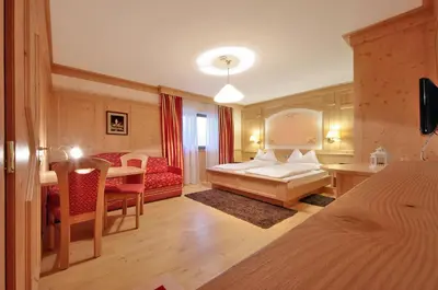 a bedroom with a bed and a table and a couch at Mountain B&B - La Scalira in Corvara in Badia