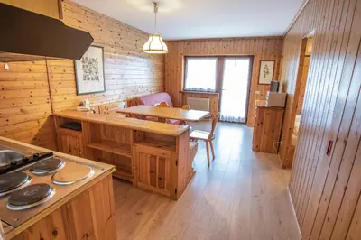 a kitchen with wooden cabinets and a table in a room at Veronza Clubresidence in Cavalese