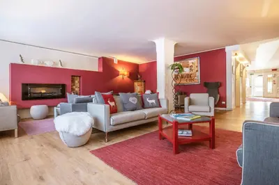 a living room with a couch and a red wall at Veronza Clubresidence in Cavalese