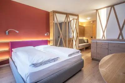 a bedroom with a bed with a table and a desk at Veronza Clubresidence in Cavalese