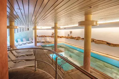 a swimming pool with a staircase leading to a building at Al Sole Clubresidence in Canazei