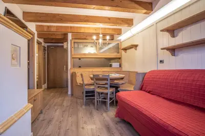 a room with a bed and a table and a kitchen at Al Sole Clubresidence in Canazei