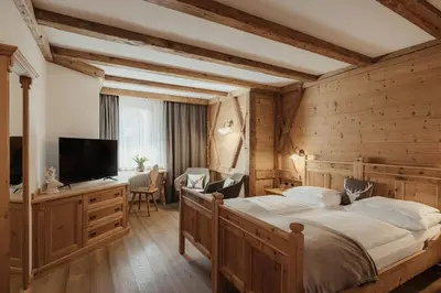 a bedroom with a large bed and a flat screen tv at Hotel Antines in La Villa