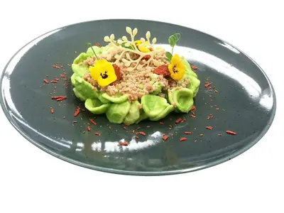 a black plate with a salad with flowers on it at Hotel Antines in La Villa