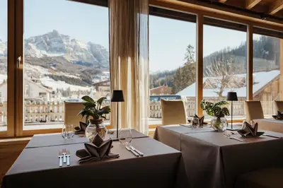 two tables in a restaurant with a view of a mountain at Hotel Antines in La Villa