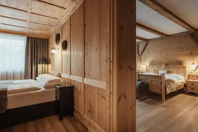 two beds in a room with wooden walls at Hotel Antines in La Villa