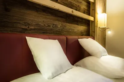 two pillows on a bed with a red head board at Albergo Posta Pederoa in La Valle
