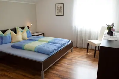 a bedroom with a bed with a blue comforter at Haus Schweitzer - Naturns in Naturno