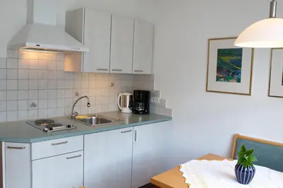 a kitchen with white cabinets and a sink at Haus Schweitzer - Naturns in Naturno
