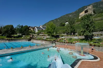 a large swimming pool with people in the water at Haus Schweitzer - Naturns in Naturno