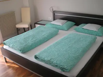 a bed with green sheets and pillows on it at Haus Schweitzer - Naturns in Naturno