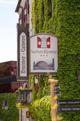 a sign for a restaurant on the side of a building at Hotel Sachsenklemme in Fortezza