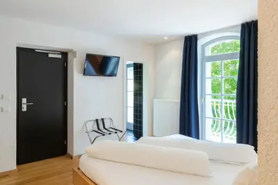 a hotel room with two beds and a window at Hotel Sachsenklemme in Fortezza