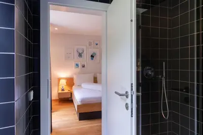 a bedroom with a bed and a bathroom with a shower at Hotel Sachsenklemme in Fortezza