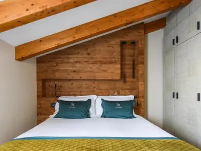 a bedroom with a bed with a wooden headboard at Hotel Antares in Selva di Val Gardena