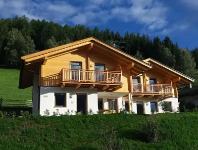 a house with a balcony on top of a field at Hütterhof in Lagundo