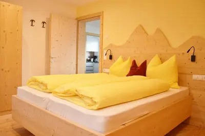 a bedroom with a large bed with a wooden headboard at Hütterhof in Lagundo