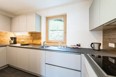 a kitchen with white cabinets and a window at Hütterhof in Lagundo