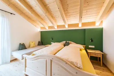 a bed in a room with a green wall at Hütterhof in Lagundo