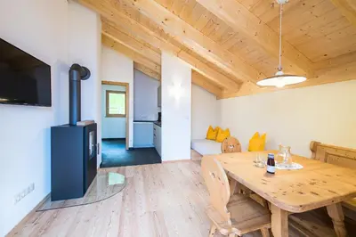 a living room with a wooden table and a tv at Hütterhof in Lagundo