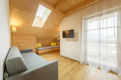 a living room with a couch and a window at Krebslechnerhof in Brunico