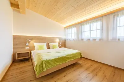 a bedroom with a bed and a window at Krebslechnerhof in Brunico