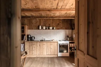 a kitchen with wooden cabinets and a stove top oven at Hütterhof Passeiertal in San Martino
