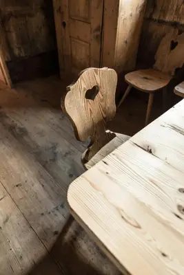 a wooden bench in a room with a table and stool at Hütterhof Passeiertal in San Martino