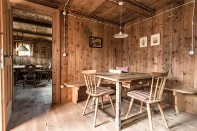 a wooden dining room with a wooden table and chairs at Hütterhof Passeiertal in San Martino