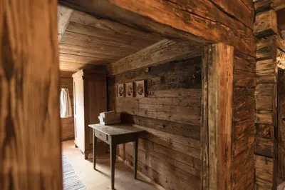 a room with a wooden wall with a table in it at Hütterhof Passeiertal in San Martino