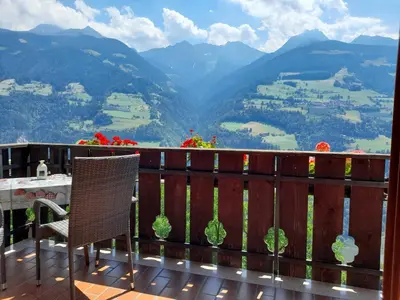 a balcony with a table and a view of mountains at Stuberhof in Rifiano
